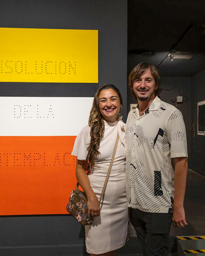 Yuyo Gardiol y Fepi Farina junto a la obra de Egar Murillo en Una Casa. La casa. Curada por Analía Solomonoff.